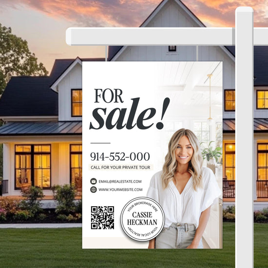 A real estate sign for a house for sale, featuring a smiling woman in a white blouse and a house with a porch and a tree in the background.